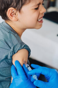 Little boy receives a vaccination in the doctors office.